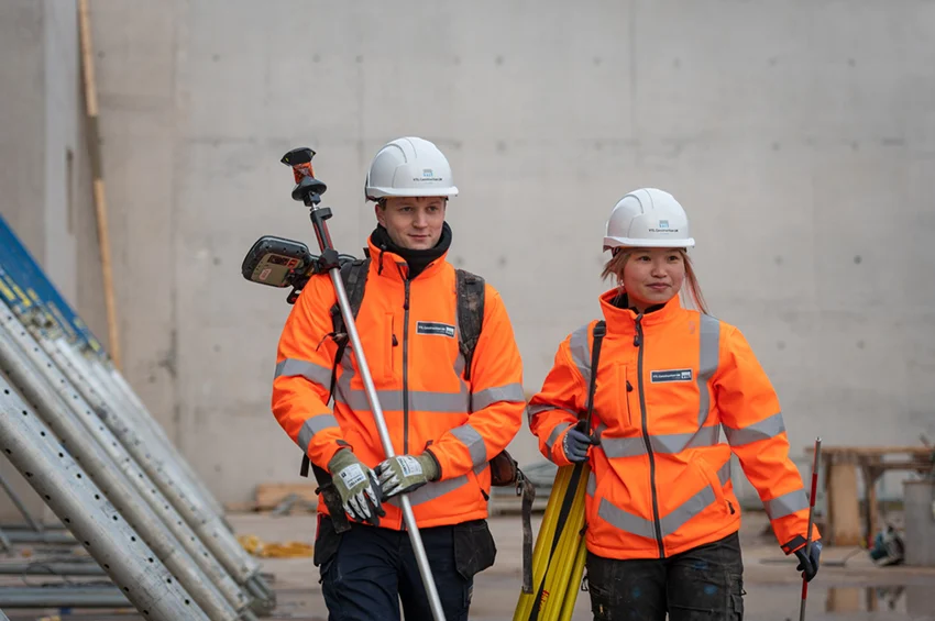 Two employees walking in uniform with PPE